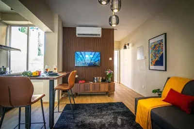 a kitchen and living room with a table and a couch at Stylish Newly Renovated Flat, 250 Meters from the Beach, Central Location with Free Parking in Limassol