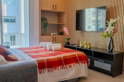 a bedroom with a large bed with a television on the wall at Beautiful One Bedroom Apartment, 186 Meters to Beach, Central Location Next to Cafes & Bars in Limassol