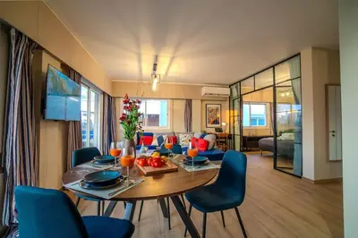 a living room with a table and blue chairs at Two Bedroom Apartment, Spacious & Newly Renovated, Three Minutes from the Beach in Limassol