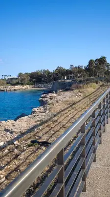 a train track next to the water with a bridge at Coralli Privileges Apt in Protaras