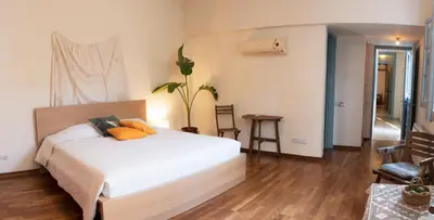 a bedroom with a white bed with orange pillows at ANANKE Home in Nicosia