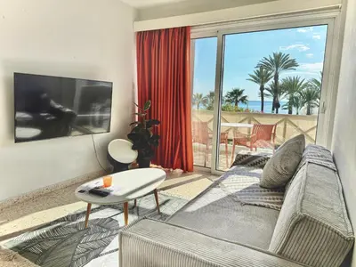 a living room with a couch and a large window at Yialos Village by Cybarco in Larnaka