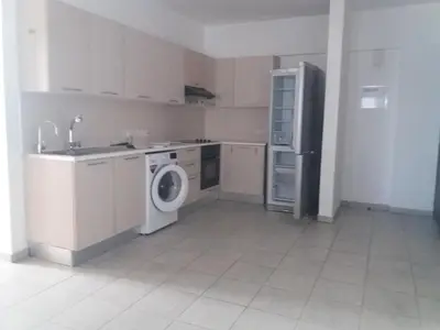 a kitchen with a washing machine and a refrigerator at alfaro57 in Nicosia