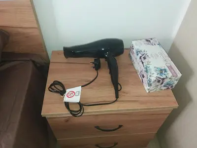 a black hair dryer sitting on a table next to a bag at alfaro57 in Nicosia