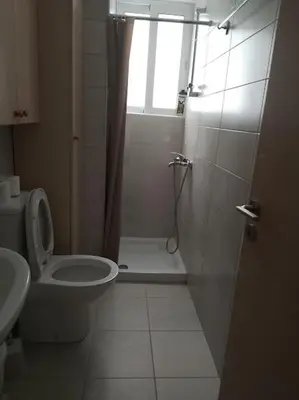 a bathroom with a toilet and a shower with a window at alfaro57 in Nicosia