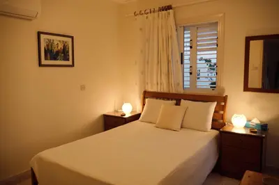 a bedroom with a white bed with two lamps at Soleil Residence - Charming 2BR Holiday House with Garden at Protaras - Konnos Area in Protaras