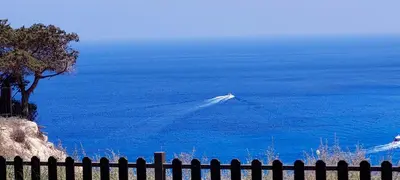 a view of the ocean from behind a fence at Soleil Residence - Charming 2BR Holiday House with Garden at Protaras - Konnos Area in Protaras