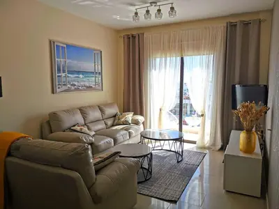 a living room with a couch and a table at Holiday apartment in Kyklades Complex with gym&pool in Paralimni
