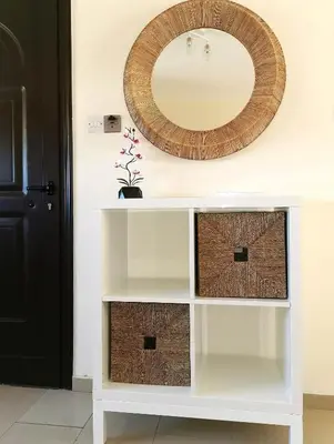 a white console table with a mirror on the wall at Holiday apartment in Kyklades Complex with gym&pool in Paralimni