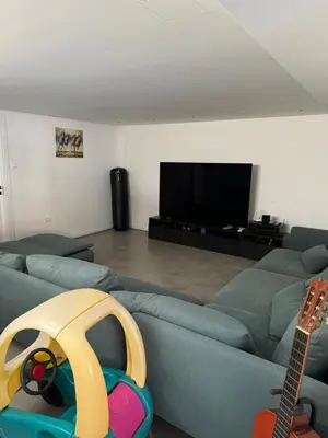 a living room with a blue couch and a guitar at Larnaca Centre Villa in Larnaka
