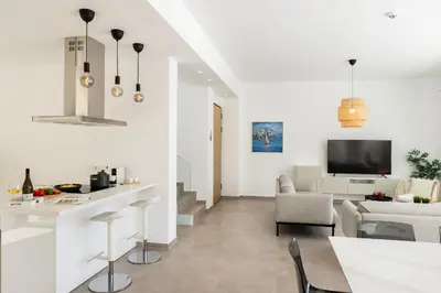 a white living room with a table and a couch at Protaras Bay View Villa 11 in Protaras