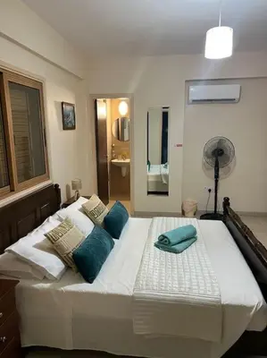 a large white bed with blue pillows on it at Palm Villa 3 bedrooms - Sleeps 6 in Ayia Napa