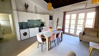 a kitchen with a table and chairs in a room at Lovely 1BR in Old Town - City Center & 4min to Beach in Scala