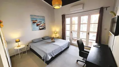 a bedroom with a bed and a desk and a window at Lovely 1BR in Old Town - City Center & 4min to Beach in Scala