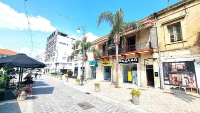 a cobblestone street with palm trees and buildings at Lovely 1BR in Old Town - City Center & 4min to Beach in Scala