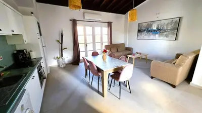 a kitchen and living room with a table and chairs at Lovely 1BR in Old Town - City Center & 4min to Beach in Scala