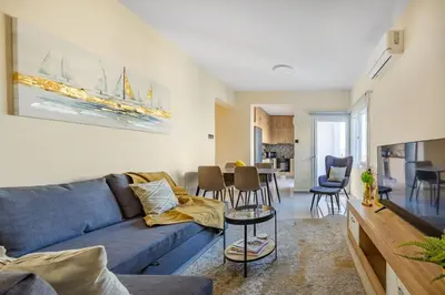 a living room with a blue couch and a table at 74 Prokymea- Steps from the Sea, Downtown, Balcony in Limassol