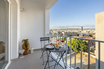 a balcony with a table with a view of a city at 74 Prokymea- Steps from the Sea, Downtown, Balcony in Limassol