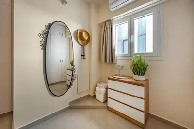 a bathroom with a mirror and a dresser and a window at 74 Prokymea- Steps from the Sea, Downtown, Balcony in Limassol