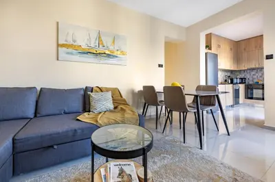 a living room with a blue couch and a table at 74 Prokymea- Steps from the Sea, Downtown, Balcony in Limassol