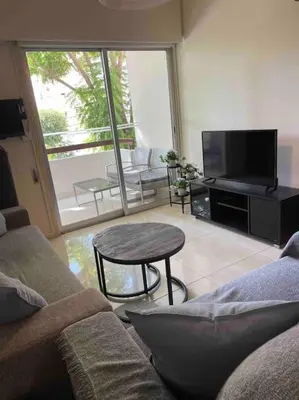 a living room with a couch and a table and a television at Cozy comfortable 2-bedroom apartment in Limassol