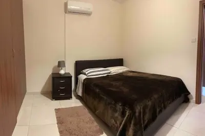 a bedroom with a bed and a night stand at Cozy comfortable 2-bedroom apartment in Limassol