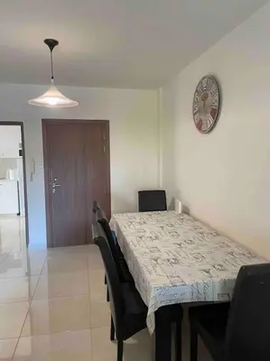 a dining room table with chairs and a clock on the wall at Cozy comfortable 2-bedroom apartment in Limassol