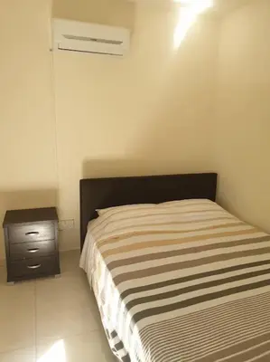 a small bedroom with a bed and a nightstand at Cozy comfortable 2-bedroom apartment in Limassol