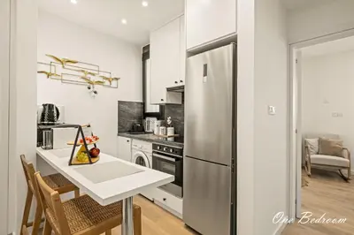 a kitchen with a stainless steel refrigerator and a table at Lazuli Hermes Apartments in Larnaka
