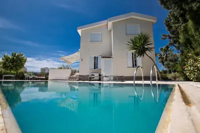 a villa with a swimming pool in front of a house at Merab Center Villas in Ayia Napa