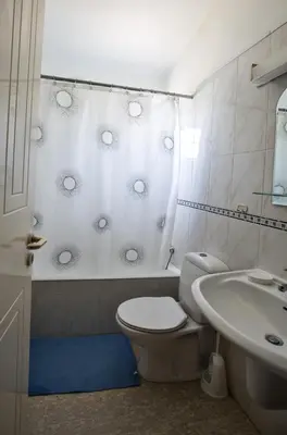 a white bathroom with a toilet and a sink at Merab Center Villas in Ayia Napa