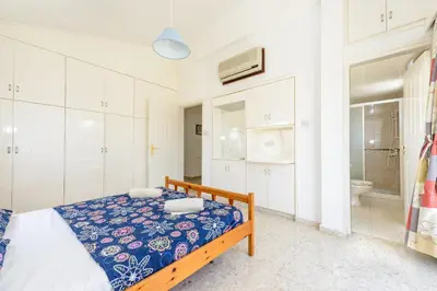 a bedroom with a bed and a bathroom at Merab Center Villas in Ayia Napa