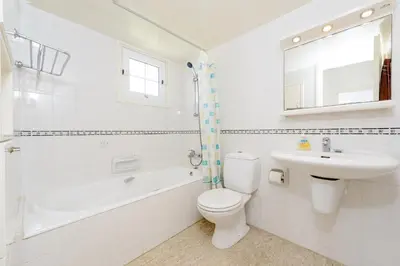 a white bathroom with a toilet and a sink at Merab Center Villas in Ayia Napa