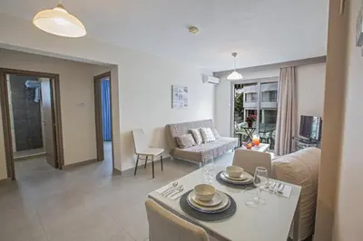 a kitchen and living room with a table and chairs at Merab Napa Suites in Ayia Napa