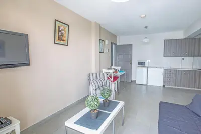 a living room with a couch and a kitchen at Merab Napa Suites in Ayia Napa