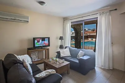 a living room with a couch and a tv at Napiana Apartments in Ayia Napa