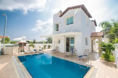 a villa with a swimming pool in front of a house at Katerina Luxury Villas in Protaras