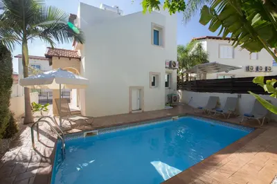 a swimming pool in front of a house at Katerina Luxury Villas in Protaras