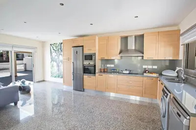 a kitchen with wooden cabinets and stainless steel appliances at Delfini Villas in Protaras