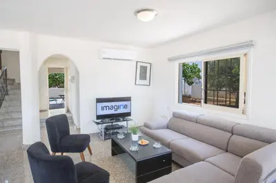 a living room with a couch and a tv at Delfini Villas in Protaras