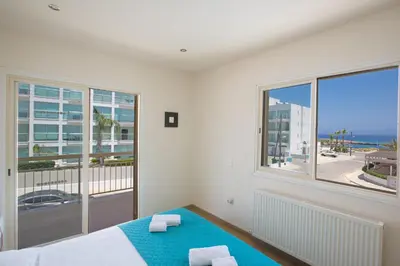 a bedroom with a bed and a large window at Delfini Villas in Protaras