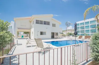 a balcony with a swimming pool and a house at Delfini Villas in Protaras
