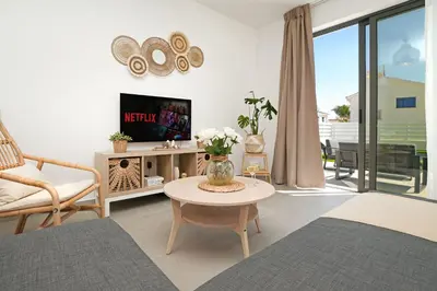 a living room with a tv and a table at Villa Flora - 3Bed all En-suite with Private Pool in Paralimni
