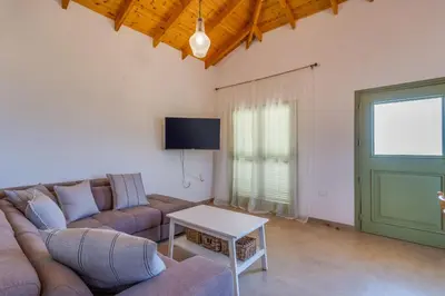 a living room with a couch and a table at Eleonas Seaview Cottages in Alaminos