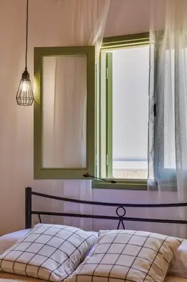 a bedroom with a bed and a large window at Eleonas Seaview Cottages in Alaminos