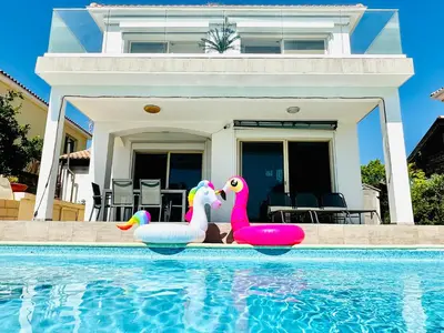 two rubber ducks in a swimming pool in front of a house at Luxury Villa LAPIS LAZULI in Meneou