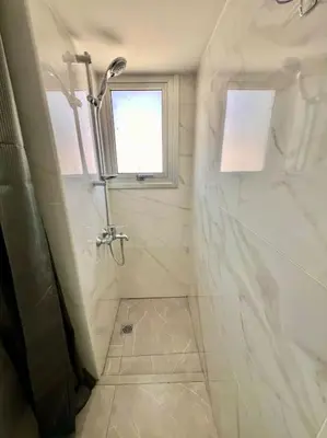 a white bathroom with a shower and a window at Cristiana Sea Breeze, Sleeps 3, Free Wifi in Limassol