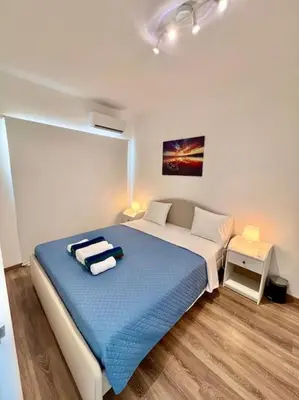 a bedroom with a large bed with a blue blanket at Cristiana Sea Breeze, Sleeps 3, Free Wifi in Limassol