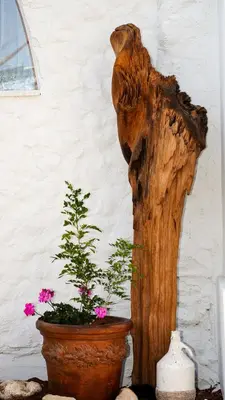 a wooden bear sculpture next to a potted plant at Sirena Bay Beach House and Luxury Suites in Protaras