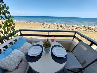 a table and chairs on a balcony with the beach at JUST on the beach Makenzy Studio in Scala